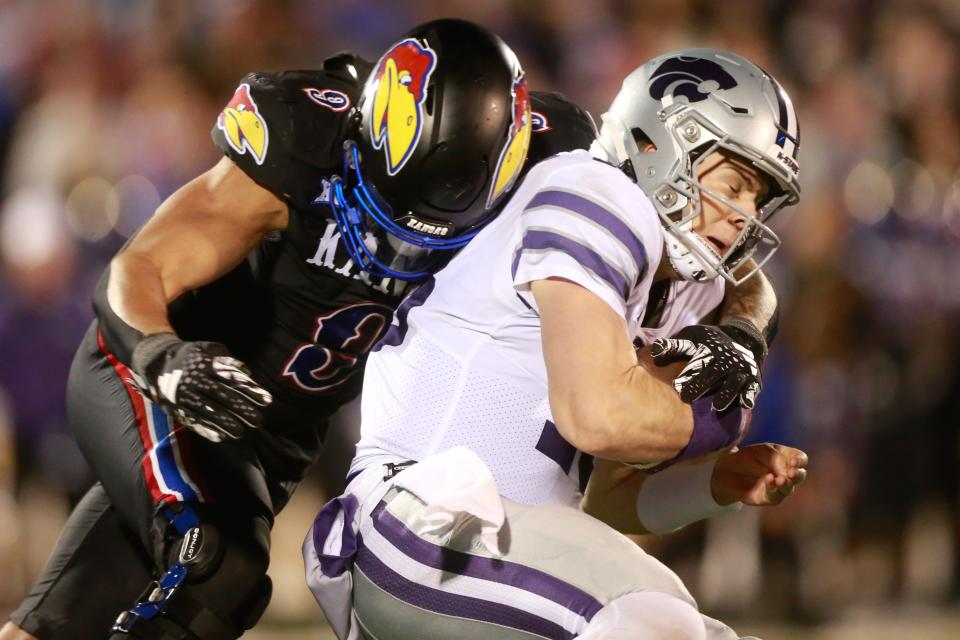 Kansas State quarterback Will Howard (18) is sacked by Kansas defensive lineman Austin Booker (9) during the fourth quarter of this year's Sunflower Showdown matchup inside David Booth Kansas Memorial Stadium.