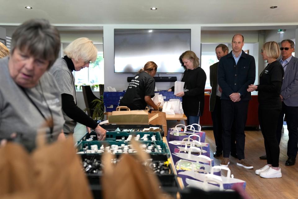 Prince William, Prince of Wales watches as toiletries are packed while speaking to Claire Hopkins, operations director, during a visit to Surplus to Supper, in Sunbury-on-Thames on April 18, 2024, in Surrey, England.