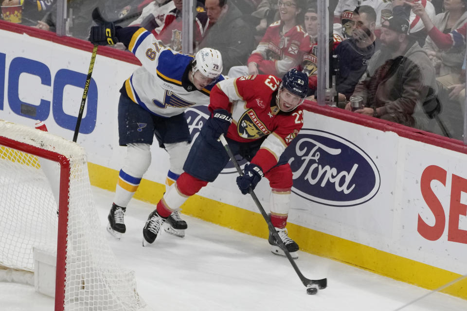 Florida Panthers center Carter Verhaeghe (23) looks to pass the puck as St. Louis Blues left wing Sammy Blais (79) defends during the first period of an NHL hockey game, Thursday, Dec. 21, 2023, in Sunrise, Fla. (AP Photo/Marta Lavandier)