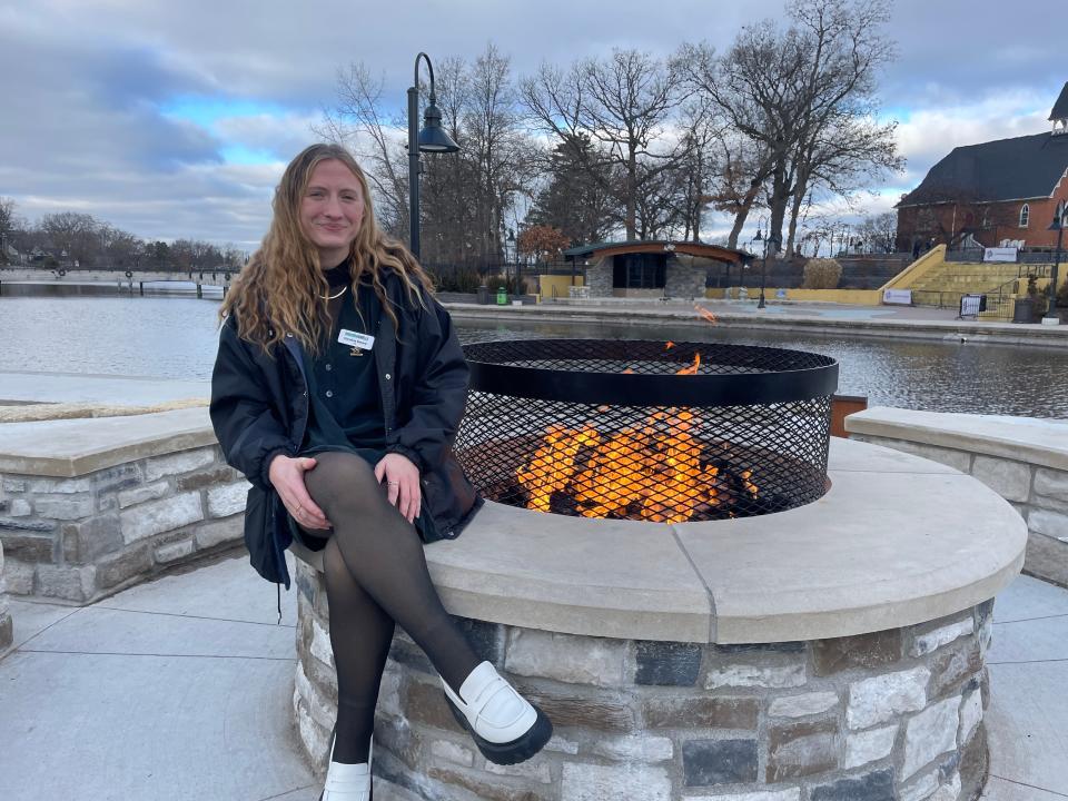Caroline Emery sits near the new firepit installed at the Brighton Mill Pond on Thursday, Jan. 4, 2024.