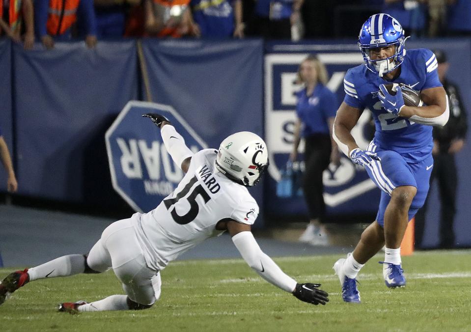 Brigham Young Cougars running back LJ Martin (27) runs past Cincinnati Bearcats defensive back Taj Ward (15).