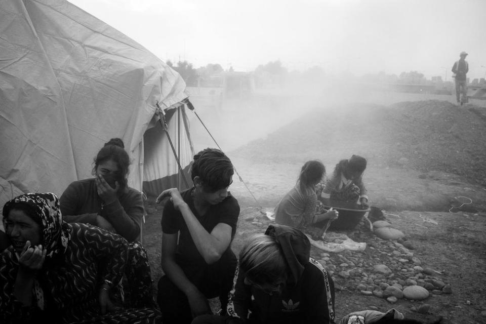 A newly arrived refugee family huddles together as dust from ongoing construction lingers in the air at the Gawilan camp in early November. | Moises Saman—Magnum Photos for TIME