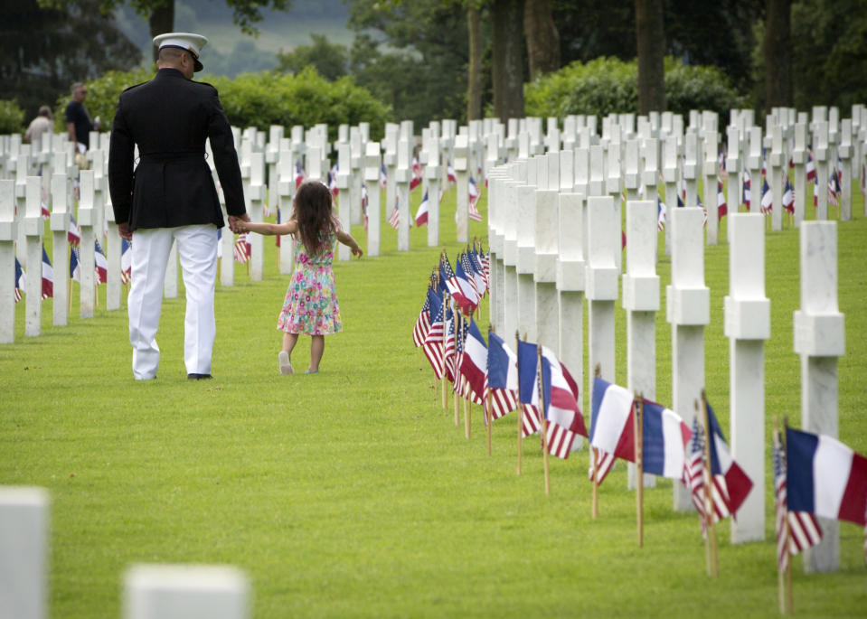 <p>A U.S. Marine Corps soldier walks with a small girl through headstones prior to a Memorial Day commemoration at the Aisne-Marne American Cemetery in Belleau, France, Sunday, May 27, 2018. The cemetery contains more that 2,000 American dead. (Photo: Virginia Mayo/AP) </p>