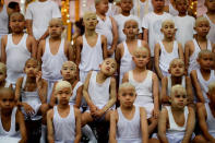 Boys with their heads smeared with thanaka bark wait to pray inside a temple after being shaved in preparation for an annual Poy Sang Long celebration, a traditional rite of passage for boys to be initiated as Buddhist novices, in Mae Hong Son, Thailand, April 2, 2018. REUTERS/Jorge Silva