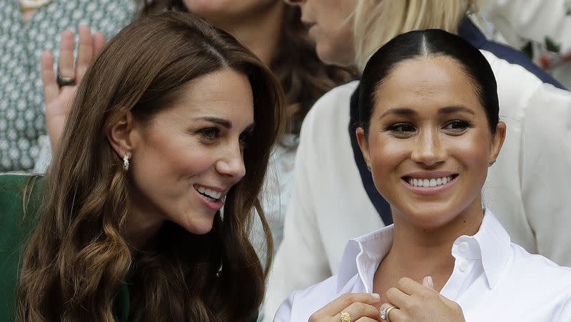 Britain’s Kate, Duchess of Cambridge, left, and Meghan, Duchess of Sussex speak as they sit in the Royal Box on Centre Court to watch the women’s singles final match between Serena Williams of the United States and Romania’s Simona Halep on day twelve of the Wimbledon Tennis Championships in London, July 13, 2019.