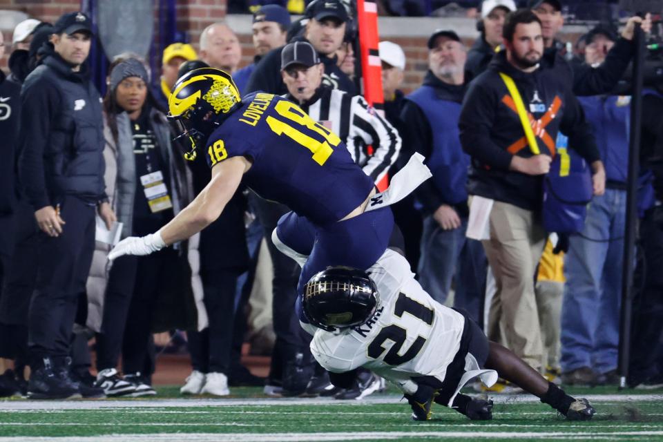 Nov 4, 2023; Ann Arbor, Michigan, USA; Michigan Wolverines tight end Colston Loveland (18) is tackled by Purdue Boilermakers defensive back Sanoussi Kane (21) in the first half at Michigan Stadium. Mandatory Credit: Rick Osentoski-USA TODAY Sports