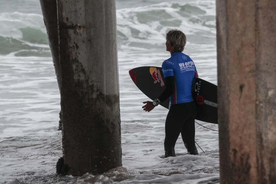 Kanoa Igarashi stops to meditate as he enters the water to compete in a semifinal heat