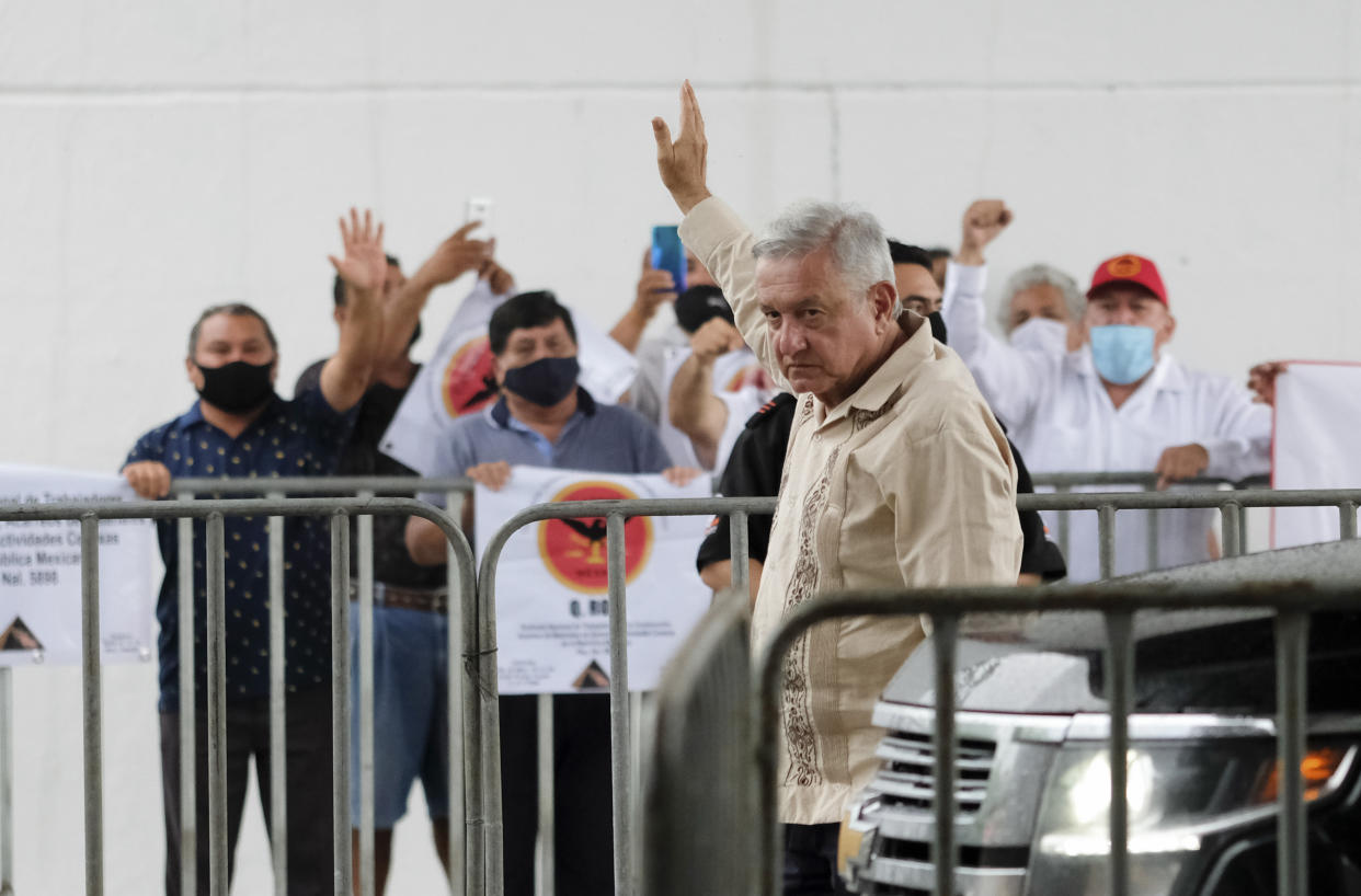 Mexican President Andres Manuel Lopez Obrador waves to supporters in Lazaro Cardenas, Quintana Roo state, Mexico, Monday, June 1, 2020. Amid a pandemic and the remnants of a tropical storm, President Lopez Obrador kicked off Mexico's return to a "new normal" Monday with his first road trip in two months as the nation began to gradually ease some virus-inspired restrictions. (AP Photo/Victor Ruiz)