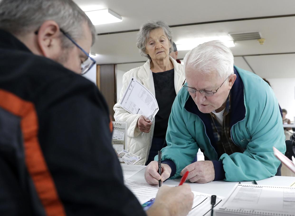 Jerry and Gail Raddatz sign in during voting April 4, 2023, at the Sunnyview Christian Church polling station in Oshkosh, Wis.