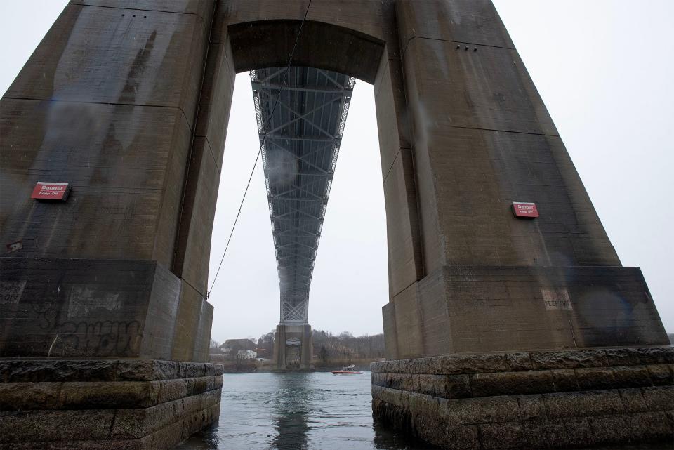 In  a steady rain, a U.S. Coast Guard patrol boat heads east Thursday through the Cape Cod Canal past the cement support columns for the Sagamore Bridge in Bourne. The support columns sit in the water at the edge of the canal.