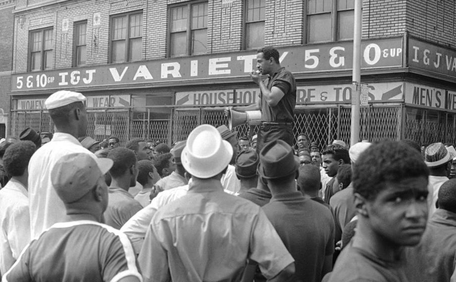 During a lethal riot in Detroit in July 1967, Rep. John Conyers uses a bullhorn to urge residents to return to their homes.