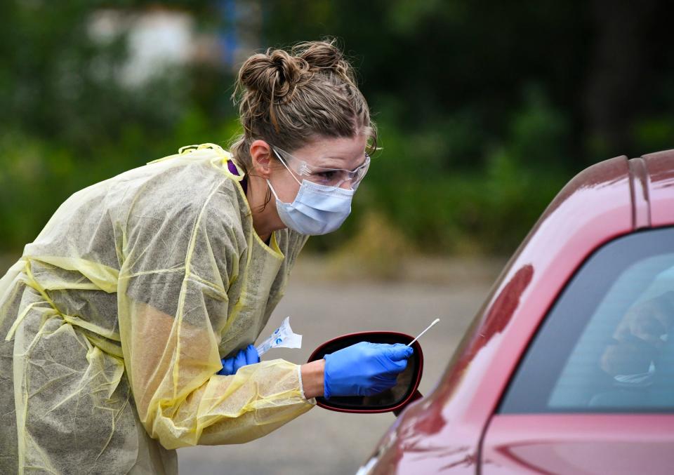 Medical assistant Angie Springer administers a drive-through COVID-19 test for a national guard member at Sartell Pediatrics Friday, Aug. 7, 2020, in Sartell. 