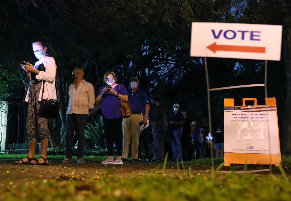 CORAL GABLES, FLORIDA - OCTOBER 19: Voters wait in line to cast their early ballots at the Coral Gables Branch Library precinct on October 19, 2020 in Coral Gables, Florida. The early voting ends on Nov. 1. Voters are casting their ballots for presidential candidates President Donald Trump and Democratic presidential nominee Joe Biden. (Photo by Joe Raedle/Getty Images)