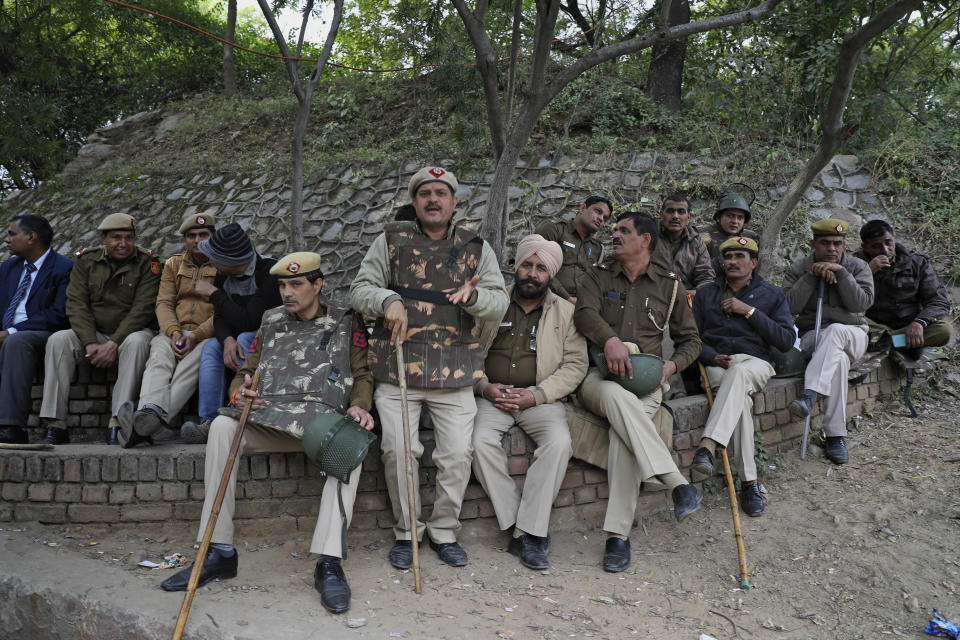 Members of Delhi police sit on a parapet outside the Jawaharlal Nehru University in New Delhi, India, Monday, Jan. 6, 2020. More than 20 people were injured in the attack opposition lawmakers are trying to link to the government. (AP Photo/Altaf Qadri)