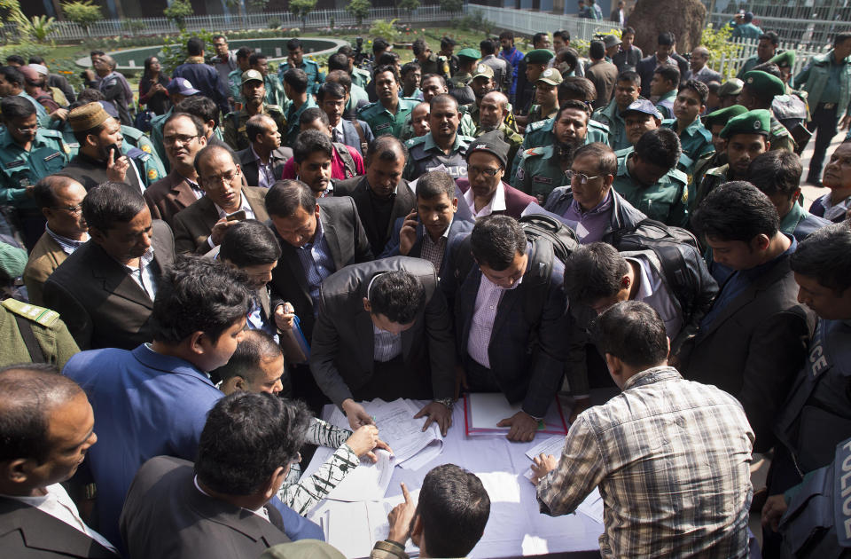 Bangladeshi elections officials gather to collect voting material at a distribution center on the eve of the general elections in Dhaka, Bangladesh, Saturday, Dec. 29, 2018. Bangladesh Prime Minister Sheikh Hasina is poised to win a record fourth term in Sunday's elections, drumming up support by promising a development bonanza as her critics question if the South Asian nation's tremendous economic success has come at the expense of its already fragile democracy. (AP Photo/Anupam Nath)