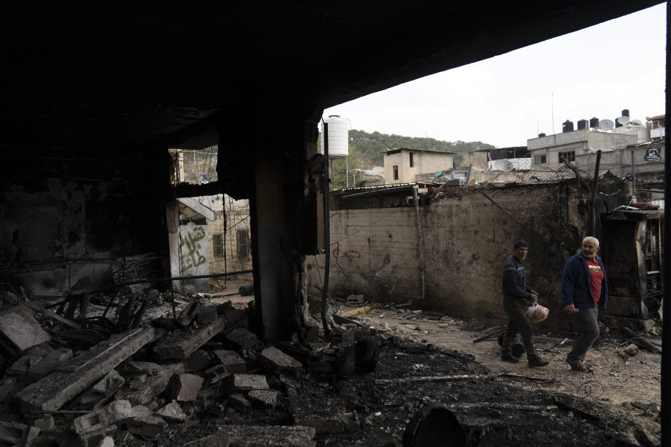 Palestinians inspect torched building in the West Bank refugee camp of Nur Shams, Tulkarem, Sunday, April 21, 2024. The Palestinian Red Crescent rescue service meanwhile said it has recovered more than a dozen of bodies from an Israeli raid in the Nur Shams urban refugee camp in the West Bank that began late Thursday. Those killed include three militants from the Islamic Jihad group and a 15-year-old boy. (AP Photo/Nasser Nasser)