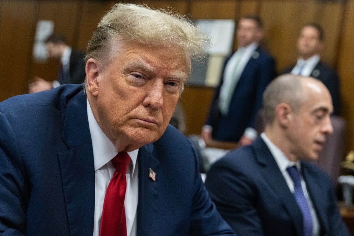 Donald Trump scowls as he sits at the defence table during day one of his first criminal trial in New York on 15 April.  (EPA)
