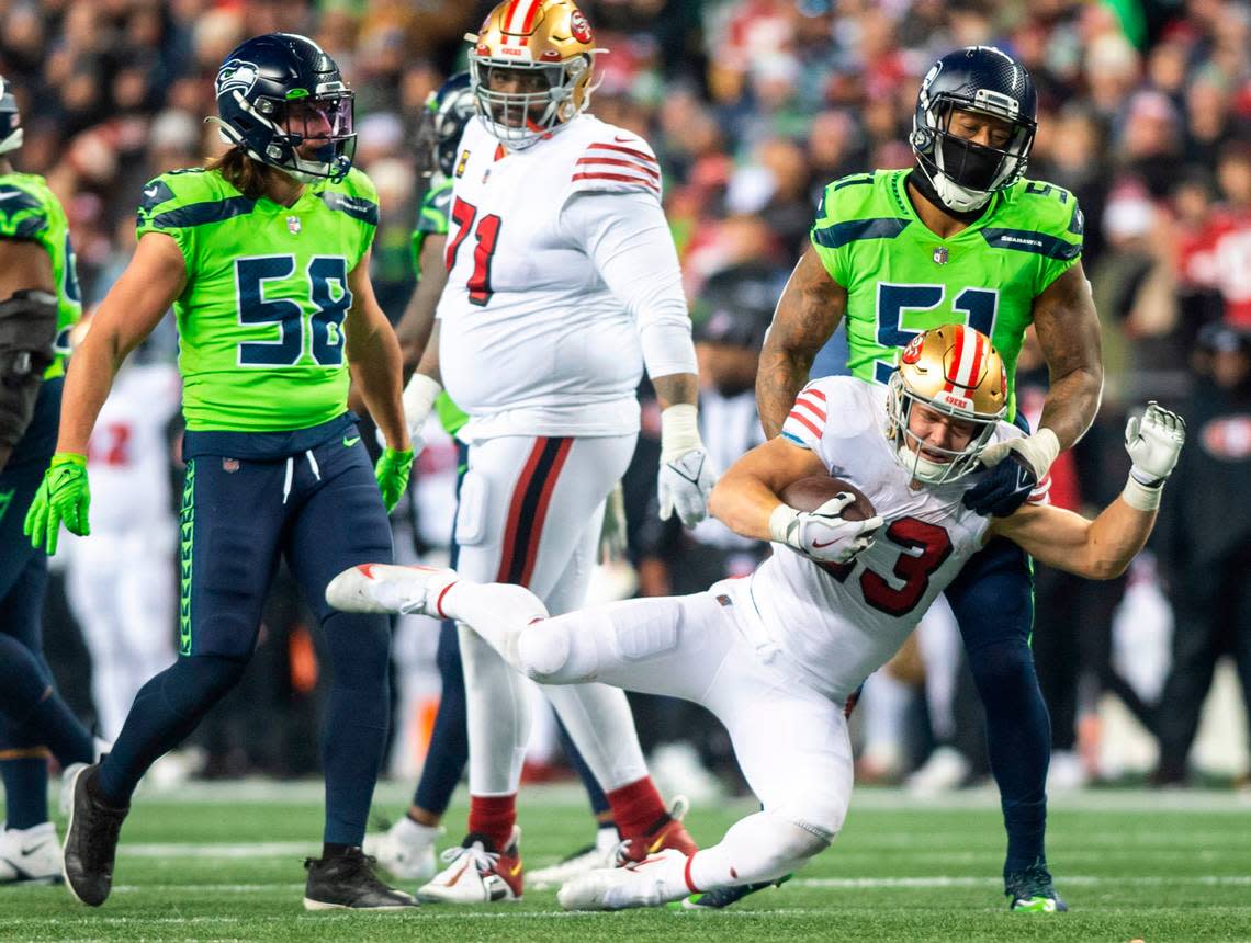 Seattle Seahawks linebacker Bruce Irvin (51) throws San Francisco 49ers running back Christian McCaffrey (23) to the ground in the fourth quarter of an NFL game at Lumen Field in Seattle Wash. on Dec. 15, 2022.