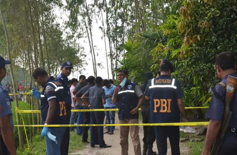 Bangladeshi police officials stand guard at the site where a Japanese citizen was shot to death by attackers in Rangpur on October 3, 2015