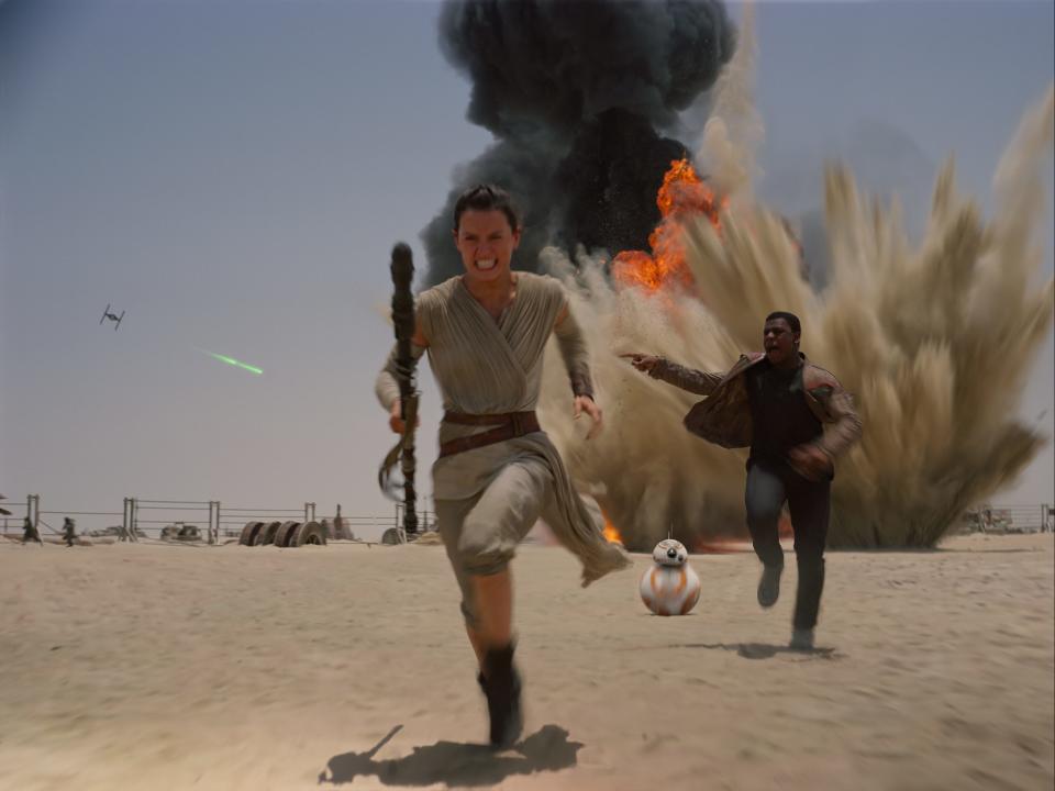 Rey (Daisy Ridley, left), BB-8 and Finn (John Boyega) hightail it in "Star Wars: The Force Awakens."