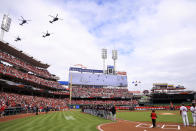 Helicopters fly over the stadium during the national anthem before a baseball between the Cleveland Guardians and the Cincinnati Reds in Cincinnati, Tuesday, April 12, 2022. (AP Photo/Aaron Doster)