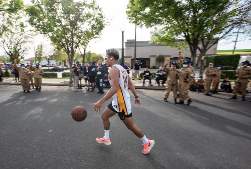 Mark Anthony Bautista bounces a basketball as he finishes the 5K during the Modesto Marathon in Modesto, Calif., on Sunday, March 27, 2022.