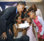 arack Obama blows out candles on his birthday cake at his 43rd birthday celebration with his wife Michelle, who is holding the cake, and daughters Sasha and Malia (R) during a fundraiser August 4, 2004 in Matteson, Illinois. (Photo by Tim Boyle/Getty Images)