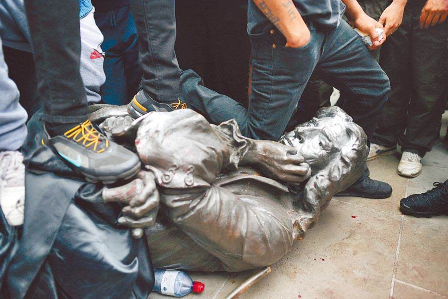 英國布里斯托7日的反種族主義示威中，抗議群眾拆卸17世紀奴隸貿易商科斯頓的雕像，並以腳壓或踐踏雕像的頸部，最後把雕像扔入河中。不過英國首相強森8日發表聲明，指責此舉違法，令人無法接受。（美聯社）