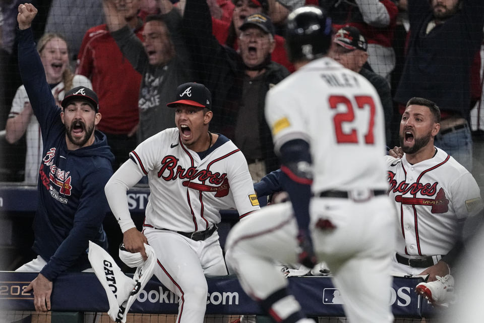 Atlanta Braves players celebrate a two-run homer by Atlanta Braves' Austin Riley (27) in the eighth inning of Game 2 of a baseball NL Division Series against the Philadelphia Phillies, Monday, Oct. 9, 2023, in Atlanta. (AP Photo/John Bazemore)