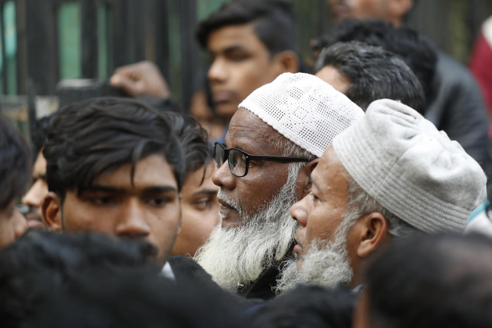 People wait to identify and collect bodies of relatives who died in a fire in New Delhi, India, Sunday, Dec. 8, 2019. Dozens of people died on Sunday in a devastating fire at a building in a crowded grains market area in central New Delhi, police said. (AP Photo/Manish Swarup)