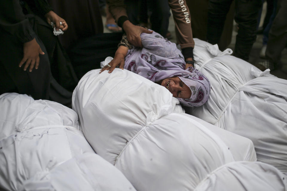 Palestinians mourn over the bodies of relatives killed in an Israeli airstrike, outside the morgue in Al-Aqsa Martyrs Hospital in Deir al Balah, the Gaza Strip, Monday, June 10, 2024. (AP Photo/Jehad Alshrafi)