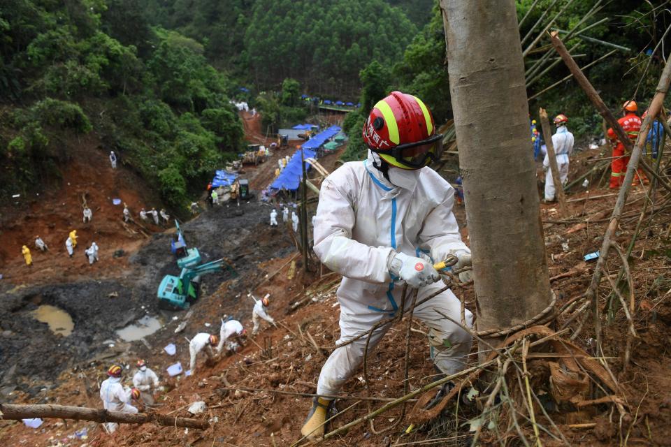 A rescuer ties a safety rope to a tree at the plane crash site in Tengxian County, south China's Guangxi Zhuang Autonomous Region, March 26, 2022.