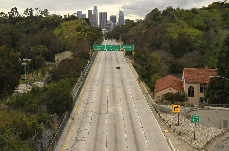 FILE - In this March 20, 2020 file photo Extremely light traffic moves along the 110 Harbor Freeway toward downtown mid afternoon in Los Angeles. Reaction to the coronavirus, change came to the United States during the third week of March in 2020. It did not come immediately, though it came quite quickly. There was no explosion, no invasion other than a microscopic one that nobody could see. (AP Photo/Mark J. Terrill, File)