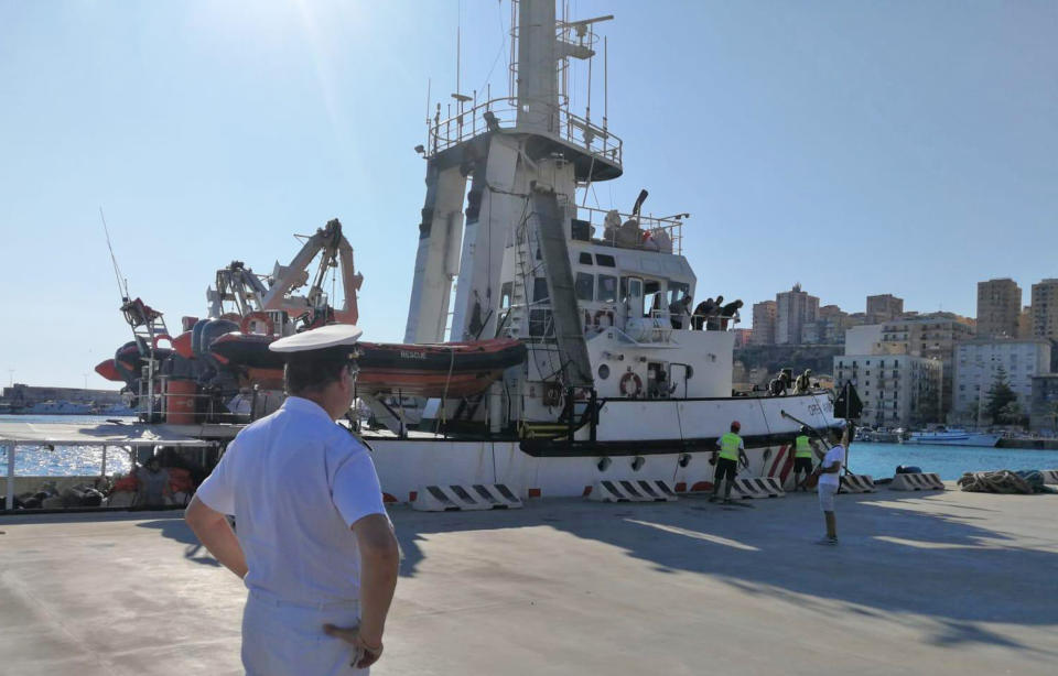 The Open Arms rescue ship is docked at the Sicilian port of Porto Empedocle, southern Italy, Wednesday, Aug. 21, 2019. An Italian prosecutor ordered the seizure of a rescue ship and the evacuation of more than 80 migrants that were aboard, capping a drama Tuesday that saw 15 people jump overboard in a desperate bid to escape deteriorating conditions on the vessel and Spain dispatch a naval ship to try to resolve the crisis. (Concetta Rizzo/ANSA via AP)