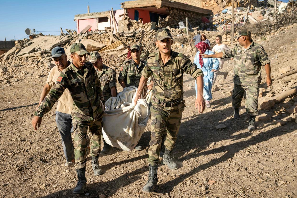 Moroccan Royal Armed Forces evacuate a body from a house destroyed in an earthquake in the mountain village of Tafeghaghte, southwest of the city of Marrakech on 9 September (AFP via Getty Images)