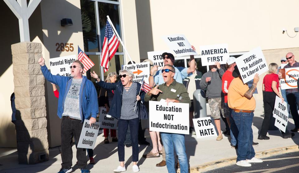 A group of protesters organized by the Lee  OP, right, gathered before the Lee County school board meeting Tuesday, Feb. 6, 2024. They are protesting a flag hung in a Riverdale High School classroom that they say violates The Stop Woke Act because it contains the words Black Lives Matter, and the LGBTQ+ and Trans flags. The Purple Group, left, who say they are non-partisan advocates for public schools, teachers, educators and parents also gathered to show support for the teacher and flag in the school.
