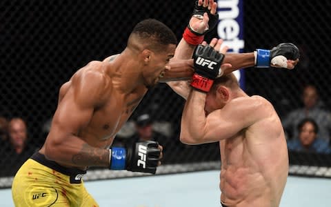 Alan Patrick of Brazil swings at Scott Holtzman in their lightweight bout  - Credit: Josh Hedges/Zuffa LLC