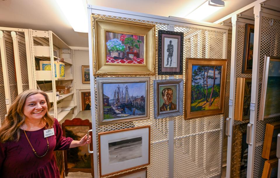 Executive director and CEO, Sarah Johnson displays stored art at The Cahoon Museum of American Art in which is expanding with the neighboring historic property, formerly a gallery and it's gardens.