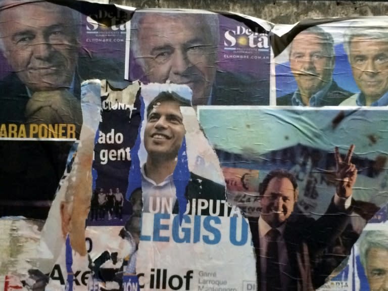 A wall with electoral posters depicting Jose Manuel de la Sota (top), Axel Kicillof (C), and Daniel Scioli (bottom, R), during primary elections in Buenos Aires on August 9, 2015