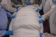 A medical team of the new Nurse Isabel Zendal Hospital prepares to rotate a patient at the COVID-19 ICU ward in Madrid, Spain, Monday, Jan. 18, 2021. As the coronavirus curve of contagion turned increasingly vertical after Christmas and New Year's, the Zendal has been busy. On Monday, 392 virus patients were being treated, more than in any other hospital in the Madrid region. (AP Photo/Bernat Armangue)