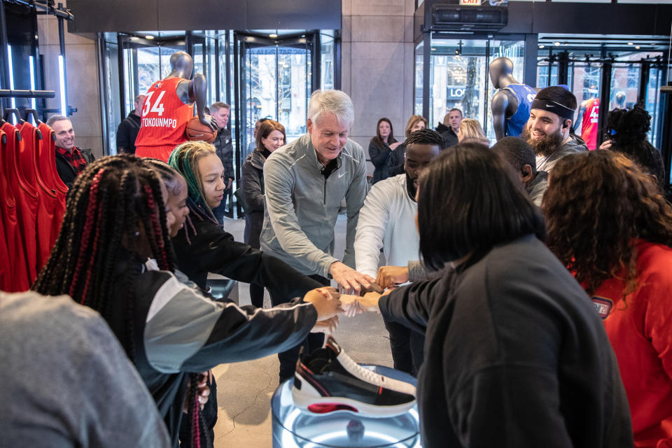 Nike CEO John Donahoe huddles with store athletes. Image courtesy of Nike