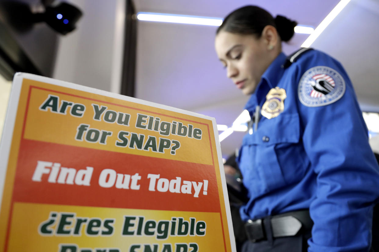 A TSA employee at Newark Liberty International Airport in Newark, N.J., on Jan. 23, 2019, looks at a food stamp program as she is given a box of provisions at a food drive to help government employees who are working without pay during the government shutdown. (Photo: Julio Cortez/AP)