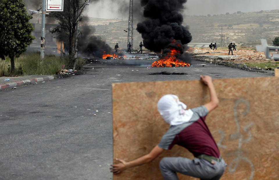 <p>A Palestinian demonstrator takes cover during a protest marking the 70th anniversary of Nakba, near the Jewish settlement of Beit El, near Ramallah, in the occupied West Bank, May 15, 2018. (Photo: Mohamad Torokman/Reuters) </p>