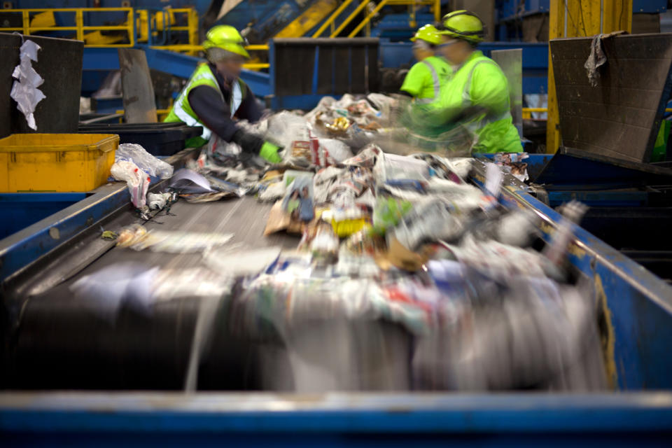Conveyor belt with employees sorting trash and recyclables.