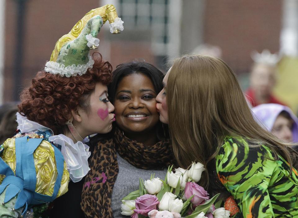 Guan-Yue Chen, Hasty Pudding Theatricals President, left, and Dan Milashewski, vice president, kisses actress Octavia Spencer during a parade to honor Spencer as the Hasty Pudding Theatricals Woman of the Year Thursday, Jan. 26, 2017, in Cambridge, Mass. (AP Photo/Stephan Savoia)