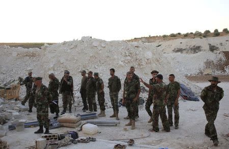 Forces loyal to Syria's President Bashar al-Assad inspect an underground base where caves were dug by rebel fighters in al-Hareeqa village, after the forces said they have regained control of the area in Hama countryside October 5, 2014. REUTERS/George Ourfalian