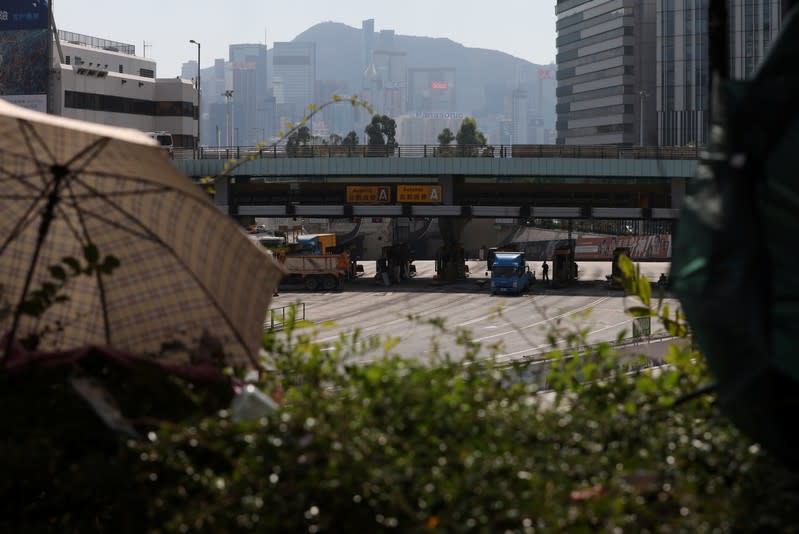 Workers repair toll booths damaged during protests, outside the Hong Kong Polytechnic University (PolyU) in Hong Kong