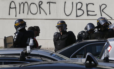 French riot police secure the Porte Maillot during a demonstration by French taxi drivers, who are on strike, to block the traffic on the Paris ring road during a national protest against car-sharing service Uber, in Paris, France, June 25, 2015. REUTERS/Charles Platiau