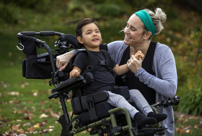 SIMI VALLEY, CA-JANUARY 12, 2022: Jamie Chong, 33 and her son Asher, 2 and 1/2, are photographed in the front yard of their home in Simi Valley. Jamie Chong said that she regularly encounters the attitude that COVID isn't a serious threat to children. Her son Asher, who turns 3 on February 11, has cerebral palsy and issues with his respiratory and gastrointestinal systems. If he gets a typical cold, Chong said, it could land him in the hospital. He is still too young to be eligible for a COVID vaccine. (Mel Melcon / Los Angeles Times)