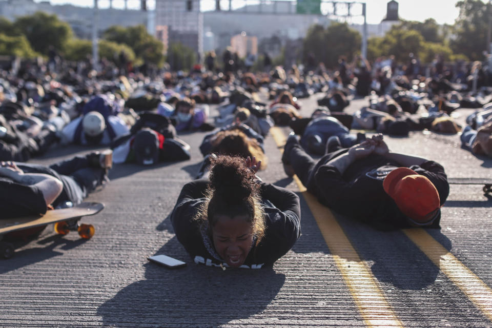 In this Monday, June 1, 2020 photo, protesters prepare to observe nine minutes of silence on the Burnside Bridge in Portland, Ore. Portland will not impose a curfew on Tuesday night for the first time in four days after several thousand demonstrators remained largely peaceful during a march the night before to protest the killing of George Floyd in Minneapolis. (Beth Nakamura/The Oregonian via AP)